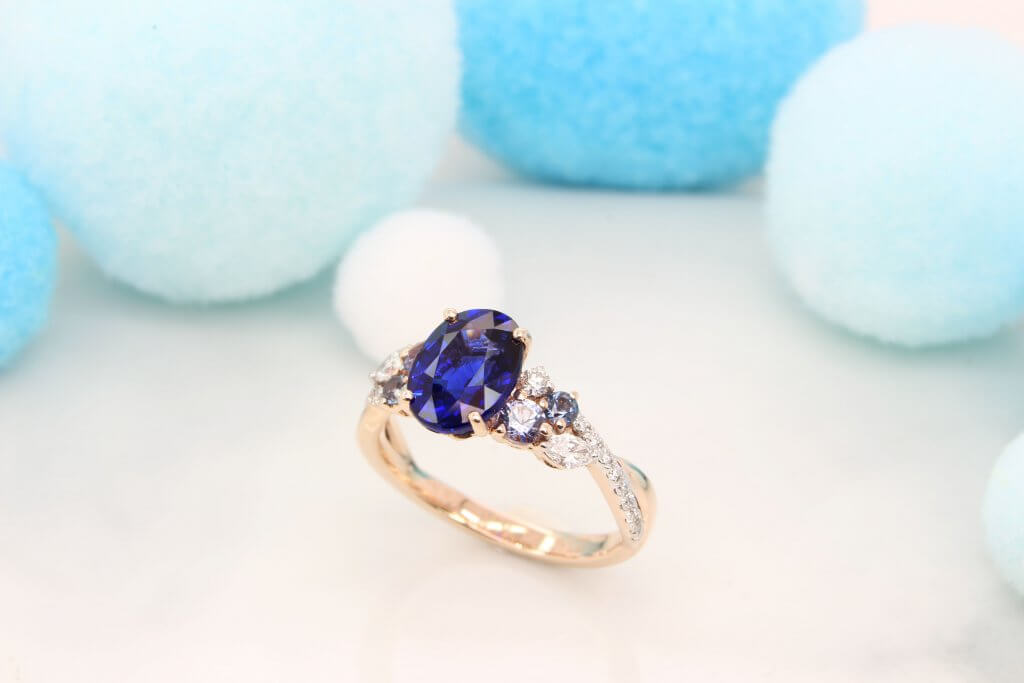 Featuring a vivid blue sapphire gem with cluster blue spinel and marquise shaped diamond design. Exceptional Sapphire engagement ring customised unique design.